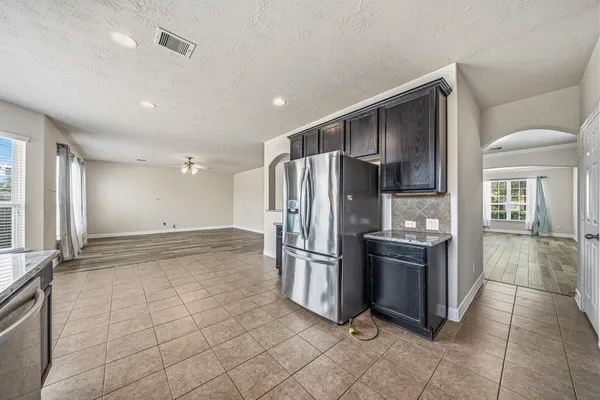 a view of a refrigerator in kitchen and windows