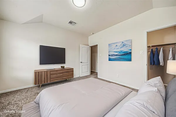 a bedroom with a bed and a flat screen tv