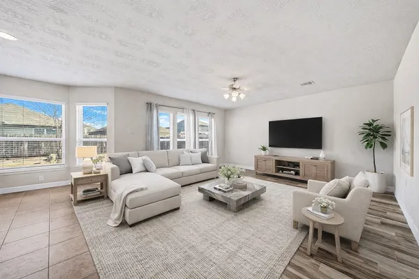 a living room with furniture a flat screen tv and a large window