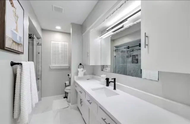 a bathroom with a double vanity sink mirror and