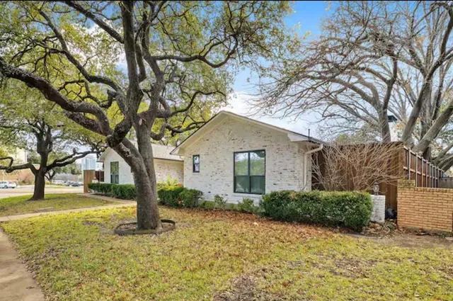 a front view of house with yard and trees around