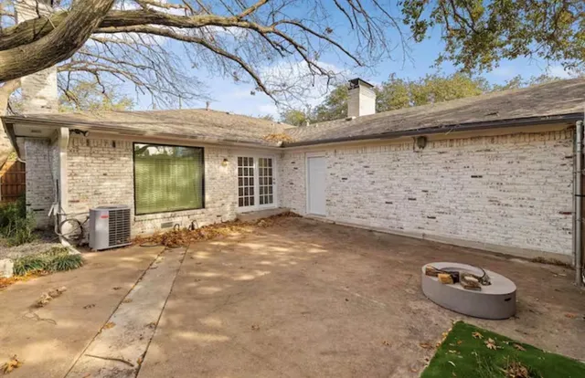 a view of a house with a small yard and sitting area