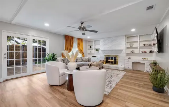 a living room with furniture a fireplace and a large window