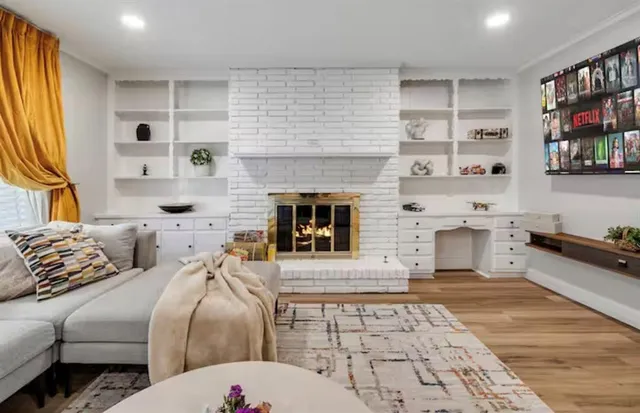 a large living room with stainless steel appliances kitchen island granite countertop a stove a sink dishwasher and a dining table with wooden floor