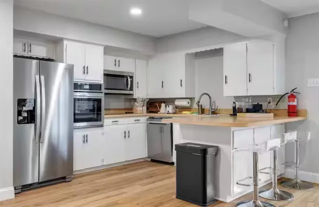 a kitchen with cabinets and wooden floor