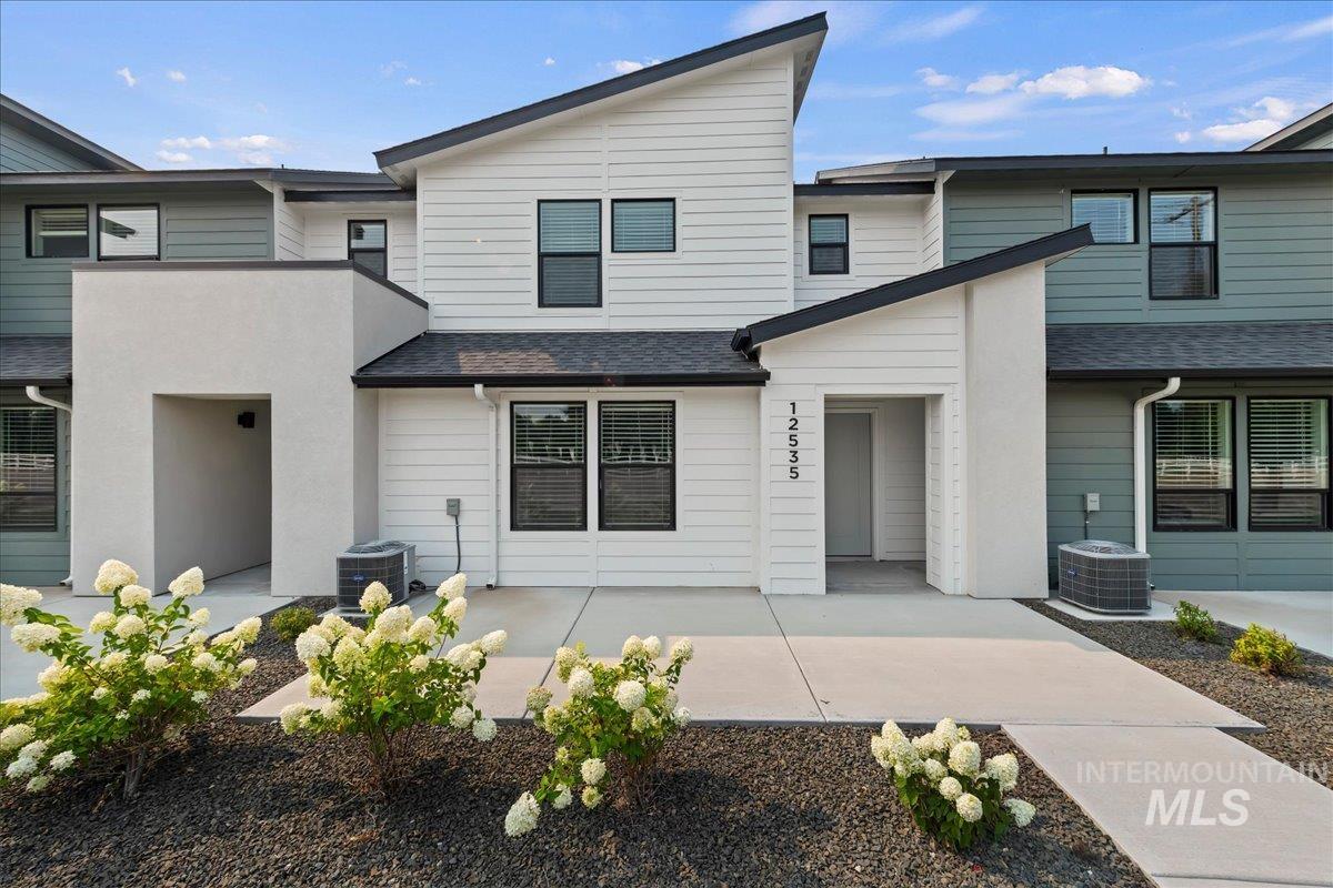 12535 West Victory Road Boise, ID 83709 - Photo 3 of 25 Contemporary exterior with a multi-textured facade, featuring white siding, green siding, and stucco accents