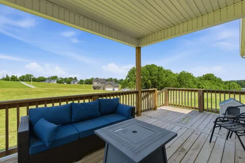 a view of a balcony with wooden floor and outdoor seating
