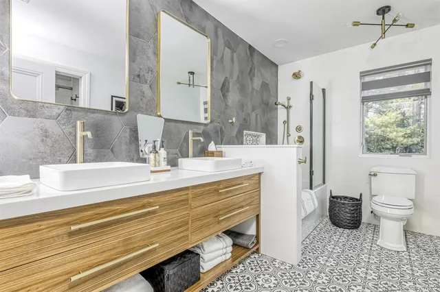 a bathroom with a sink a toilet a mirror and shower