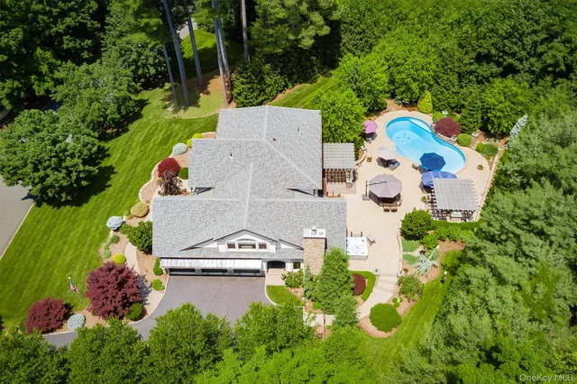 an aerial view of a house with a yard and swimming pool