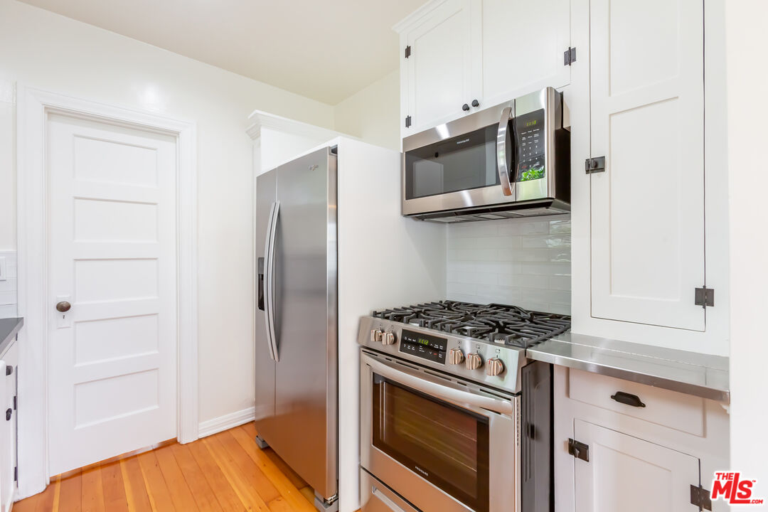 9980 Braddock Drive Culver City, CA 90232 - Photo 17 of 29 a kitchen with stainless steel appliances white cabinets and a stove
