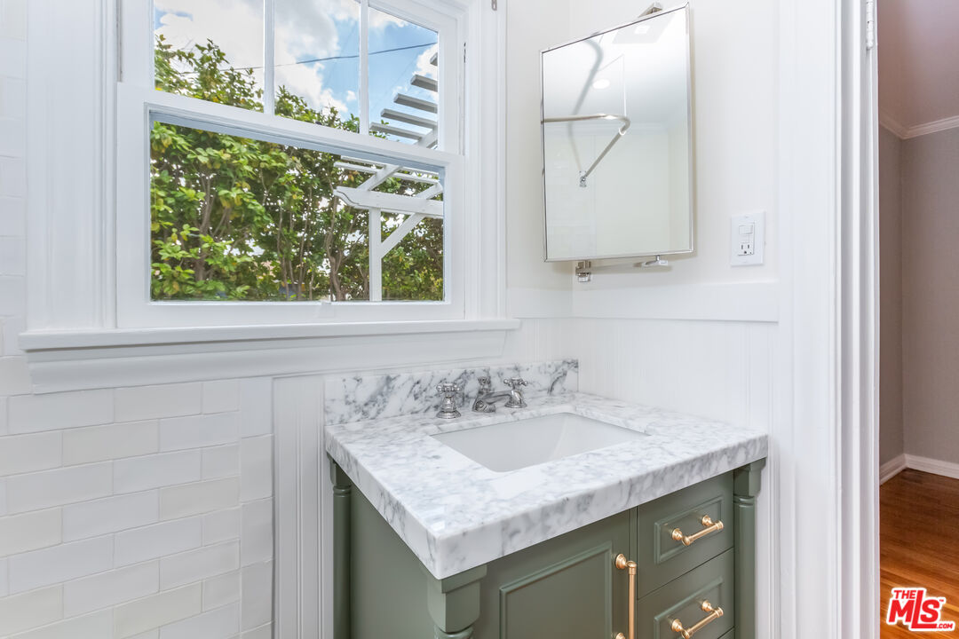 9980 Braddock Drive Culver City, CA 90232 - Photo 25 of 29 a bathroom with a granite countertop sink and a mirror