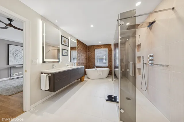 a bathroom with a double vanity sink a mirror a bathtub and shower