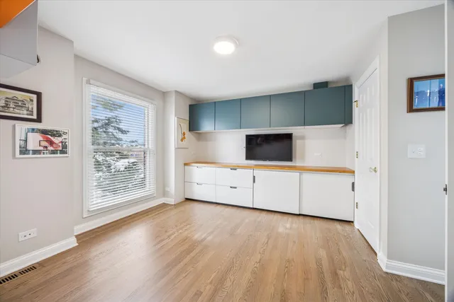 a view of a living room with wooden floor and kitchen view