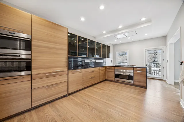 a large kitchen with stainless steel appliances wooden cabinets and granite counter tops