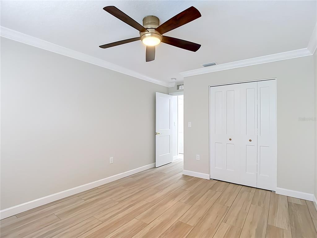4536 Mitcher Road New Port Richey, FL 34652 - Photo 20 of 46 an empty room with wooden floor ceiling fan and windows