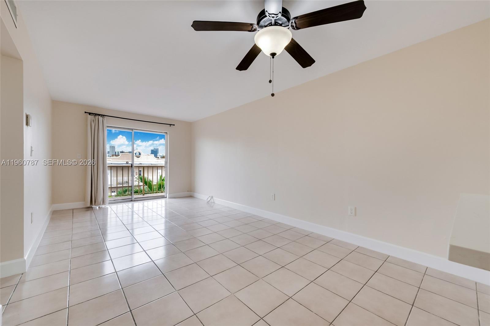 1661 Southwest 3rd Street, Unit 25 Miami, FL 33135 - Photo 4 of 24 an empty room with windows and chandelier fan