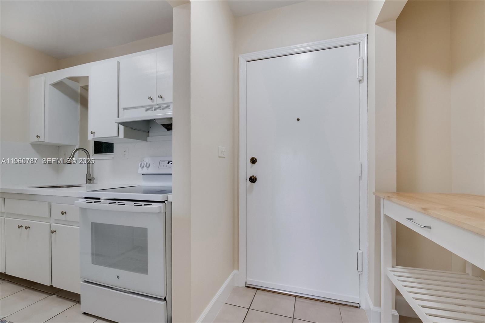 1661 Southwest 3rd Street, Unit 25 Miami, FL 33135 - Photo 6 of 24 a kitchen with white cabinets and white appliances