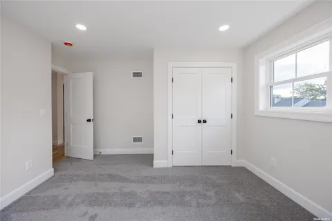 an empty room with windows and closet