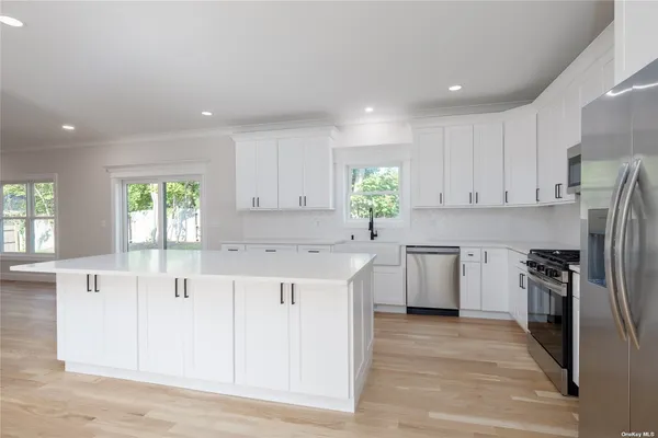 a kitchen with white cabinets and stainless steel appliances