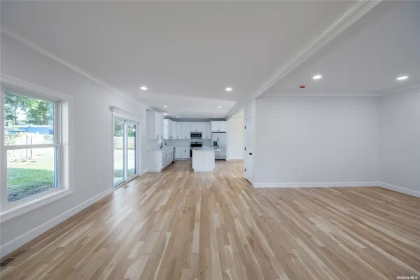 a view of empty room with wooden floor and windows