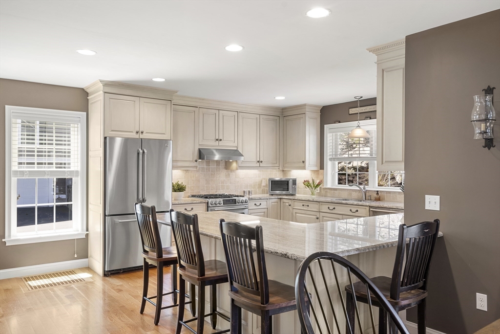62 Leggs Hill Road Marblehead, MA 01945 - Photo 8 of 36 a kitchen with stainless steel appliances granite countertop a dining table chairs stove refrigerator and cabinets