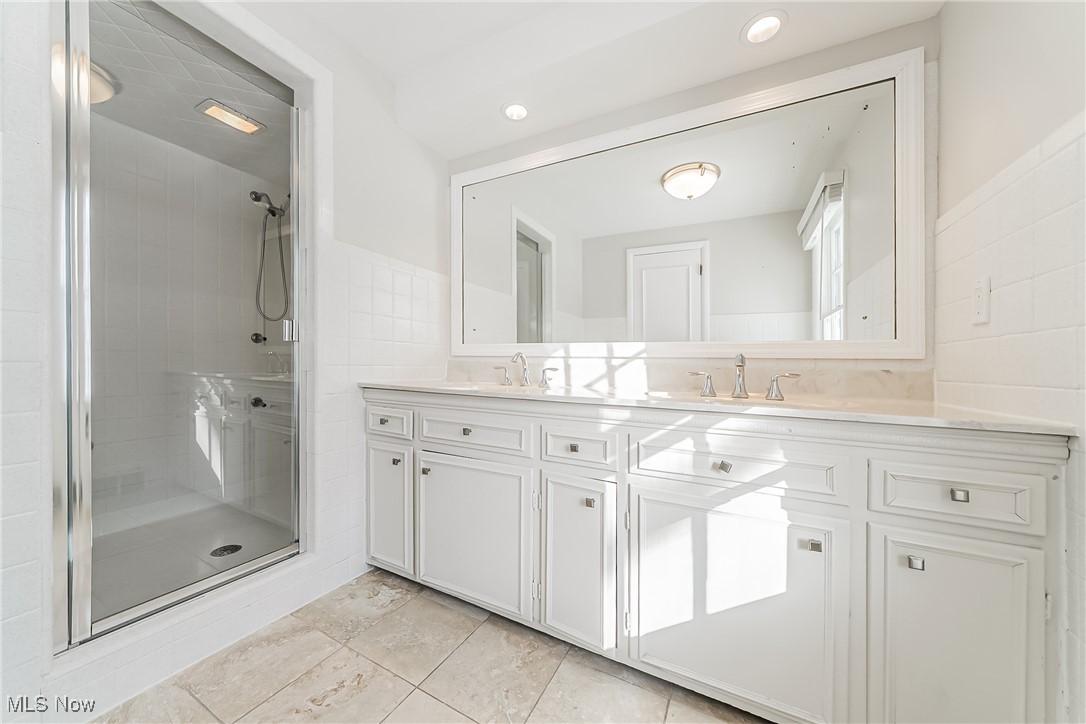 18201 Shelburne Road Cleveland, OH 44118 - Photo 19 of 36 Master bathroom with tile walls, vanity, and a shower with door