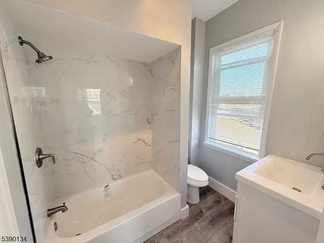 a bath room with a toilet sink and a bath tub