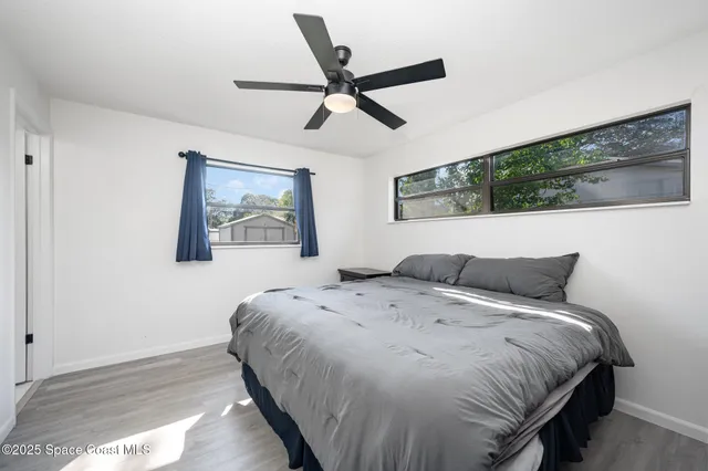 a bedroom with a bed and painting on the wall