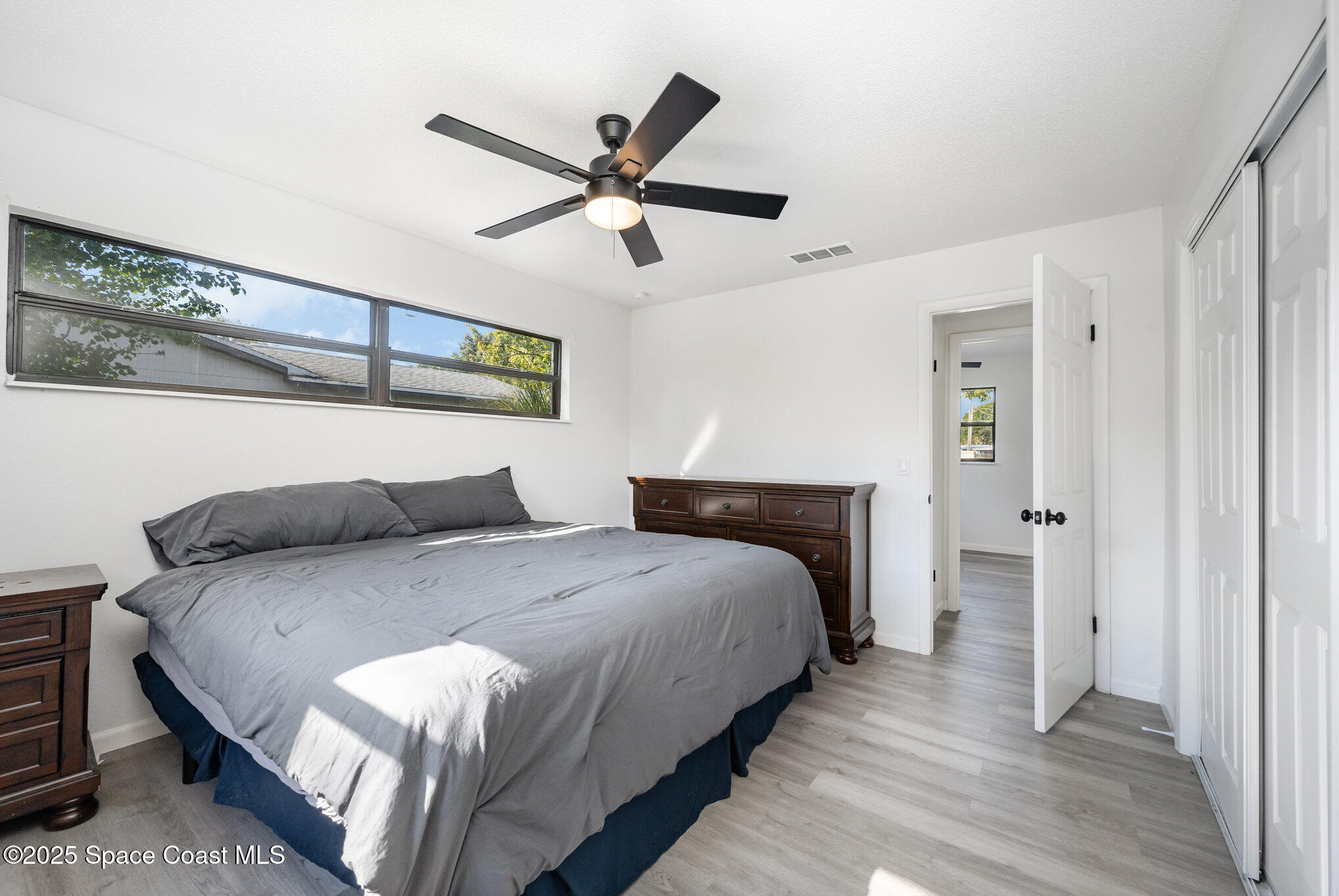 1121 Coronado Drive Rockledge, FL 32955 - Photo 13 of 25 a bedroom with a bed and a chandelier