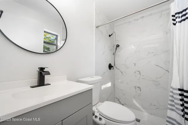 a bathroom with a toilet sink and a mirror