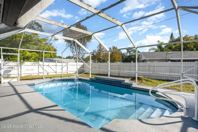 a view of a swimming pool with a patio and a yard