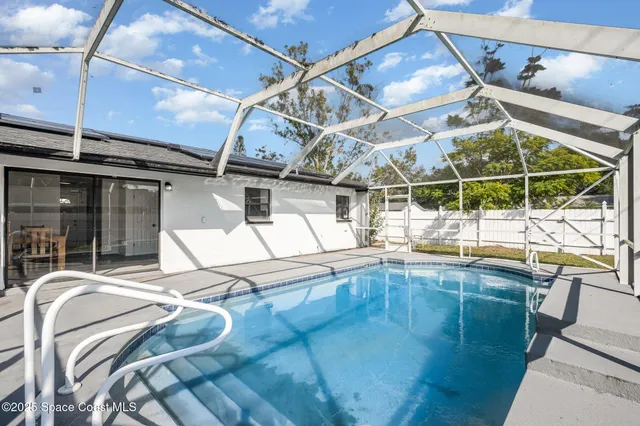 a indoor swimming pool with a glass door open kitchen view