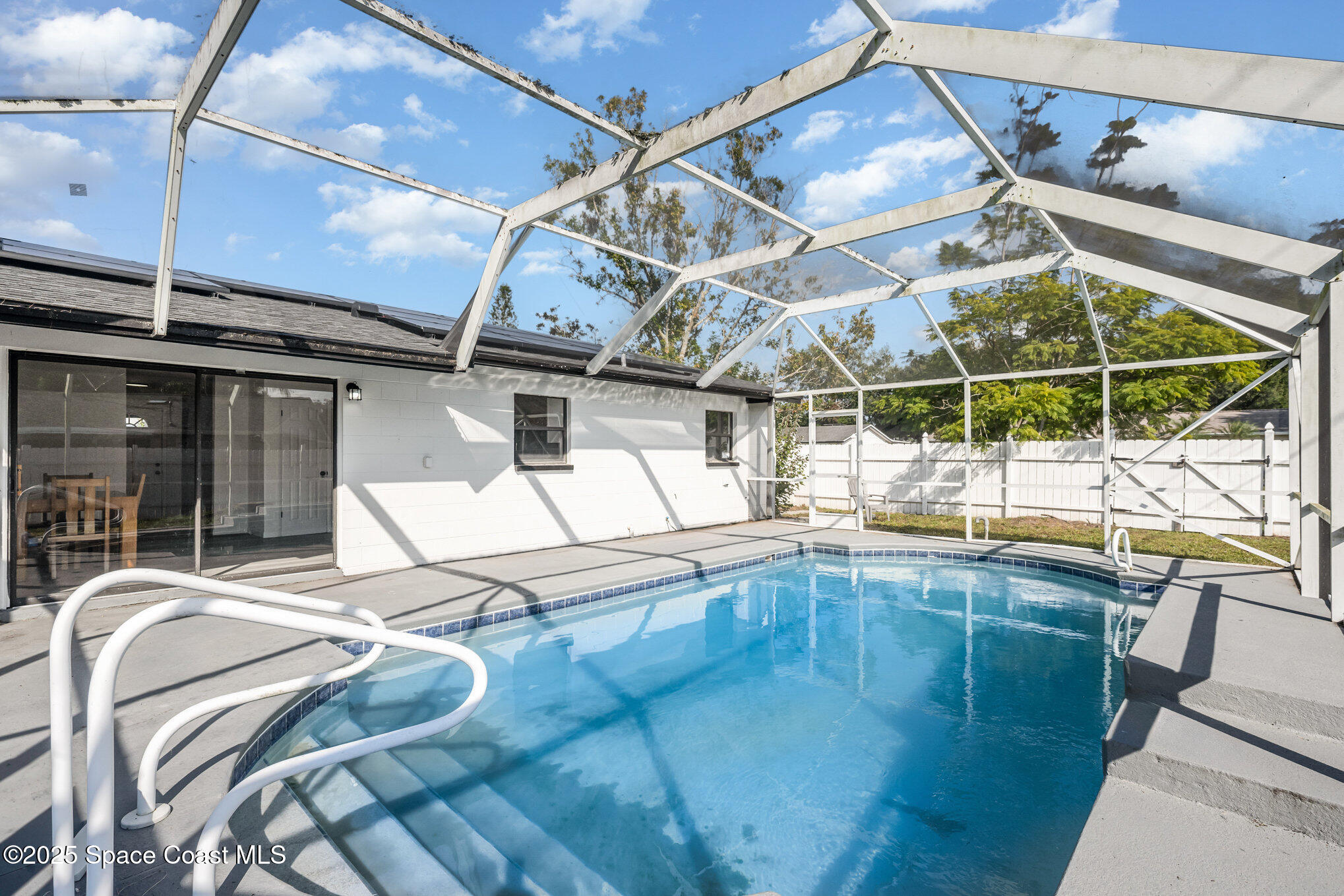 1121 Coronado Drive Rockledge, FL 32955 - Photo 22 of 25 a indoor swimming pool with a glass door open kitchen view