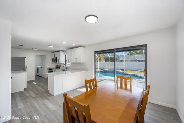 a dining room with furniture and a floor to ceiling window