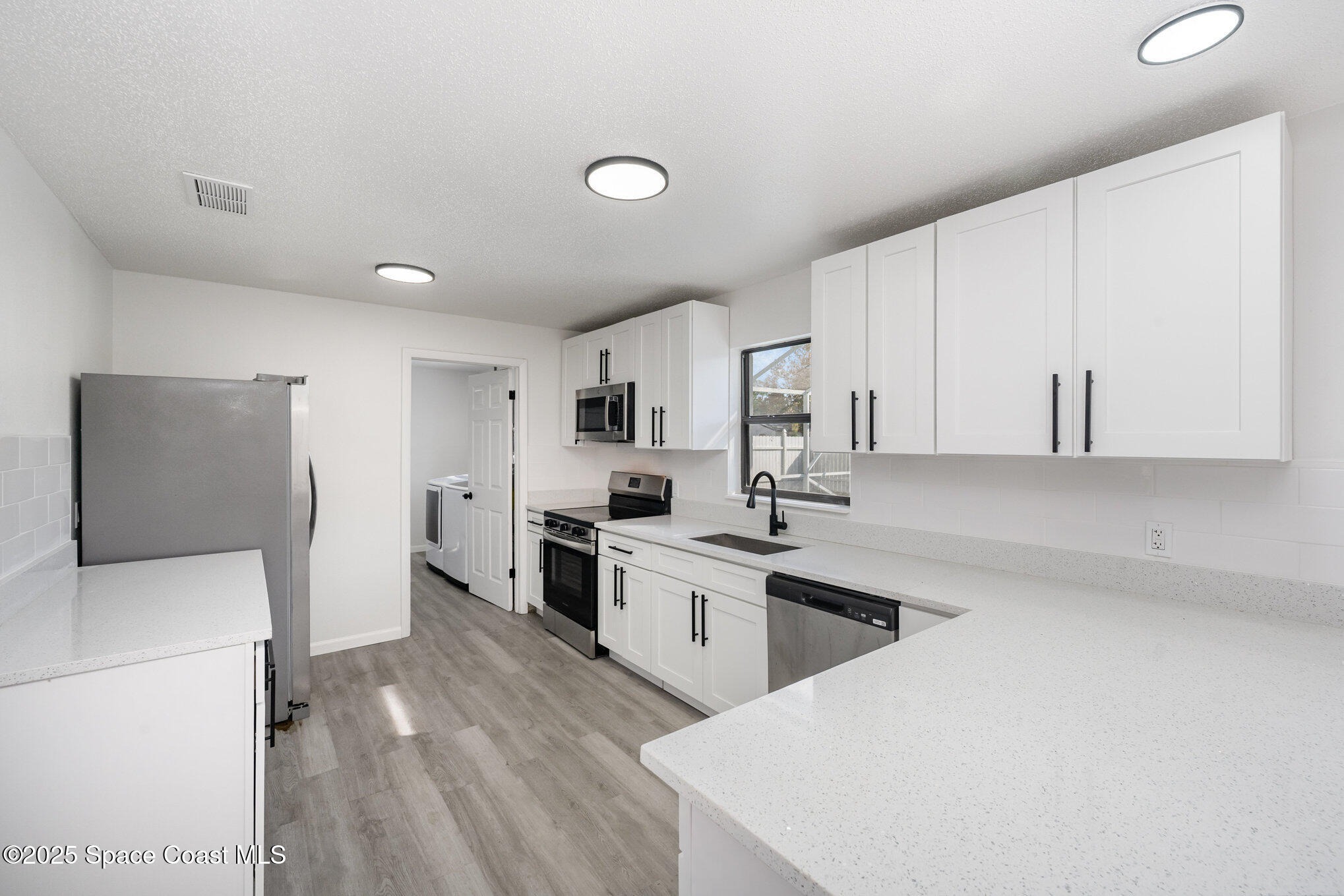 1121 Coronado Drive Rockledge, FL 32955 - Photo 8 of 25 a kitchen with white cabinets and white appliances