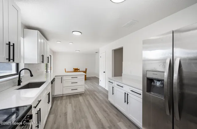 a kitchen with white cabinets and stainless steel appliances