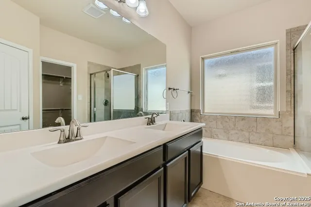 a bathroom with a tub sink and mirror