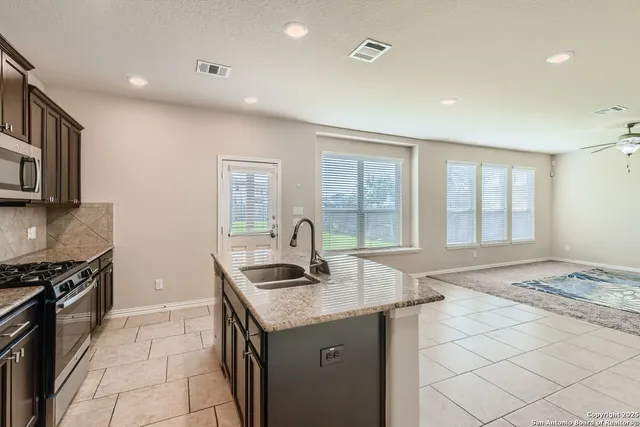 a kitchen with granite countertop a stove and a sink