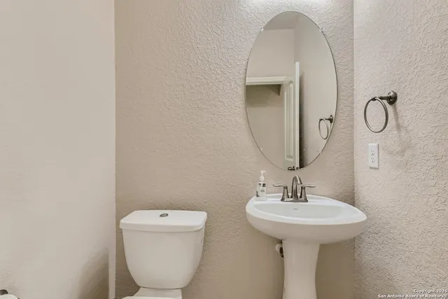 a bathroom with a toilet sink and mirror
