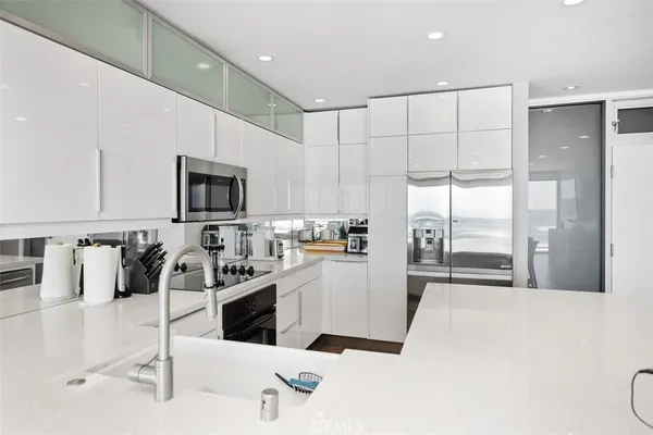 a kitchen with a sink a stove and chairs