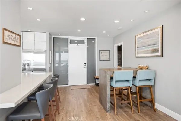 a kitchen with stainless steel appliances granite countertop a table chairs sink and cabinets