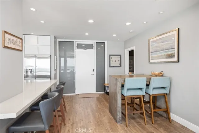 a kitchen with stainless steel appliances granite countertop a table chairs sink and cabinets