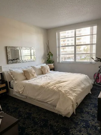 a large bed sitting in a bedroom next to a window