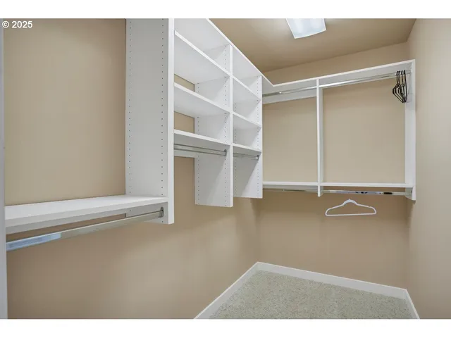 a view of walk in closet with empty racks