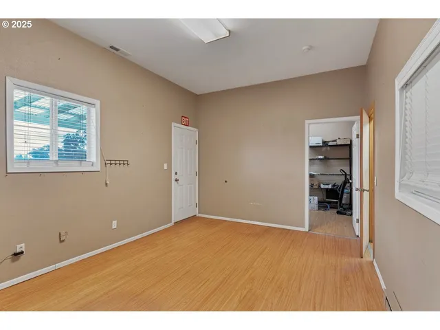 a view of an empty room with closet and a window