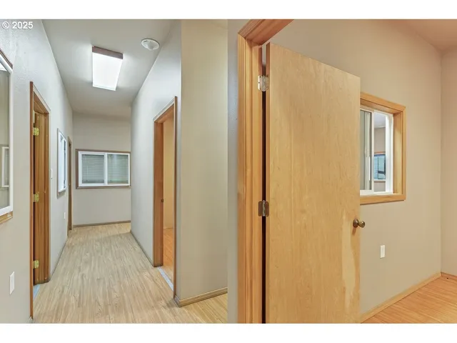 a view of hallway with bathroom and wooden floor