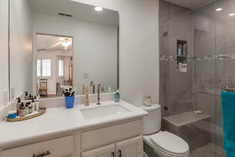 a bathroom with a double vanity sink toilet mirror and bathtub