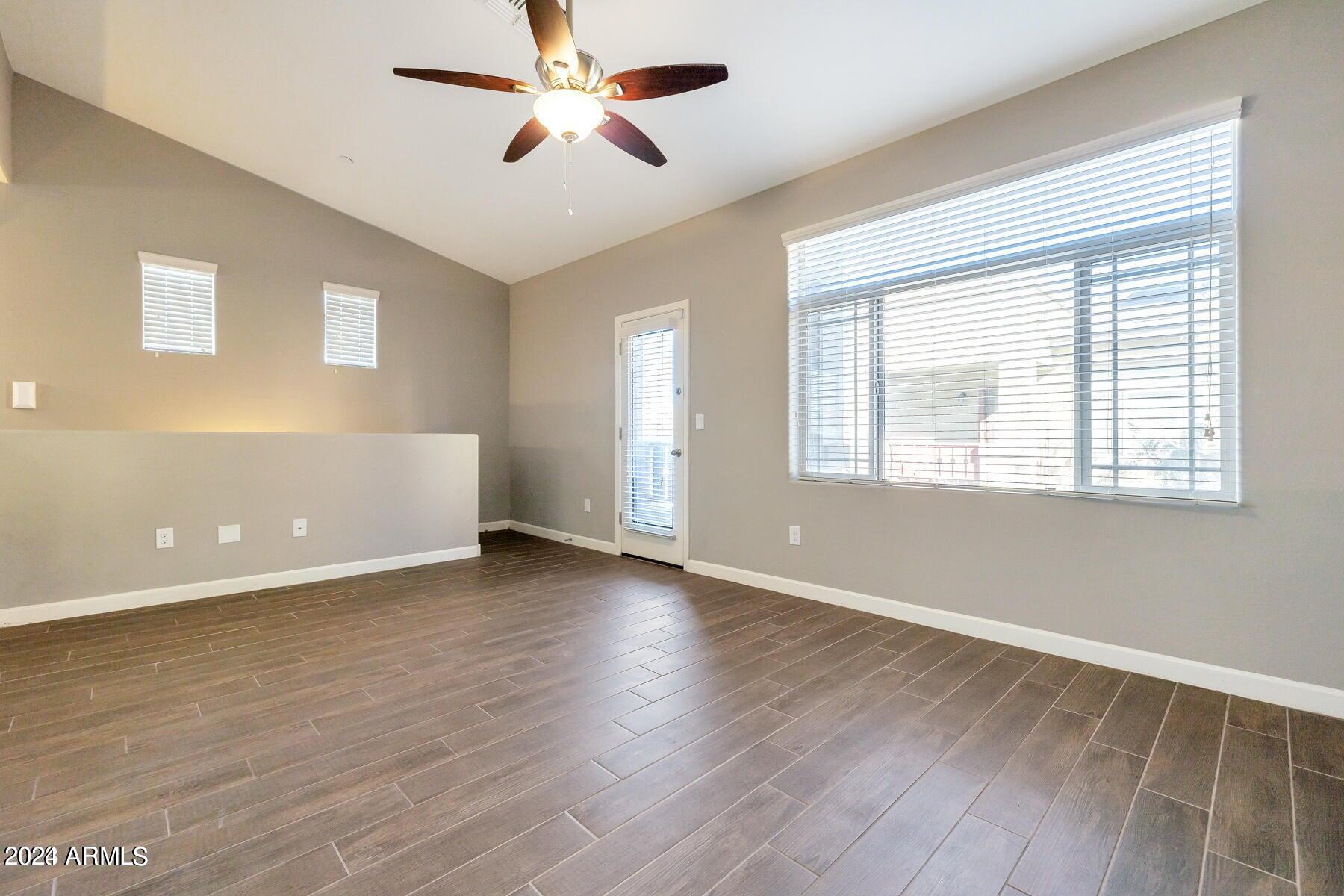 2150 West Alameda Road, Unit 1169 Phoenix, AZ 85085 - Photo 16 of 26 a view of an empty room with wooden floor and a window