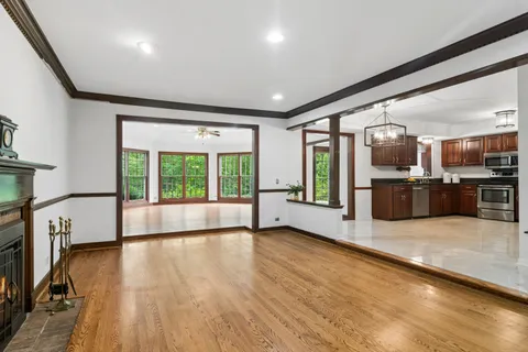 a large space with stainless steel appliances wooden floor and a large window