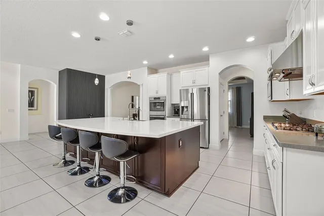 a kitchen with a sink a counter top space cabinets and stainless steel appliances